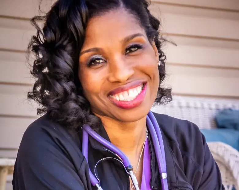 woman smiling wearing nursing uniform 