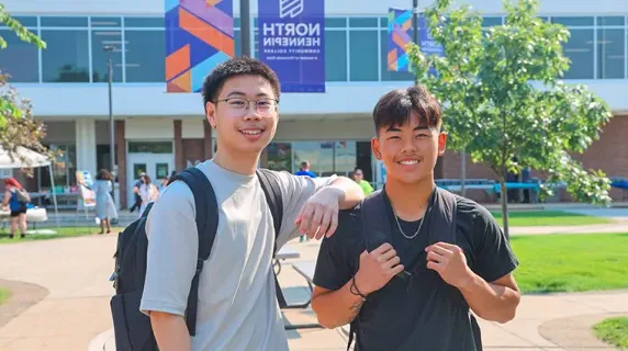 two students outside smiling on a nice day