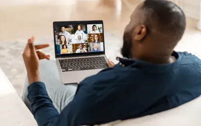man on a laptop speaking to people on laptop 