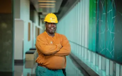 man wearing a construction hat standing in a hallway 