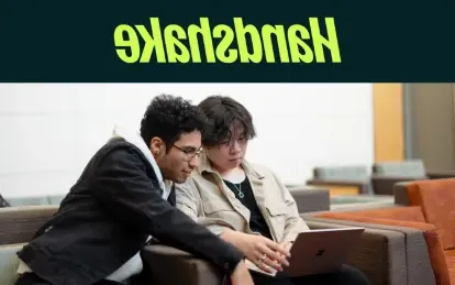 two students looking at a laptop 