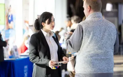 student speaking with an employer at a job fair 