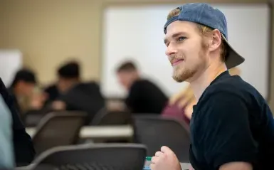 Male student smiling in a classroom 