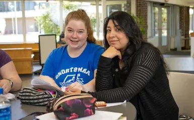 a student smiling next to their mentor