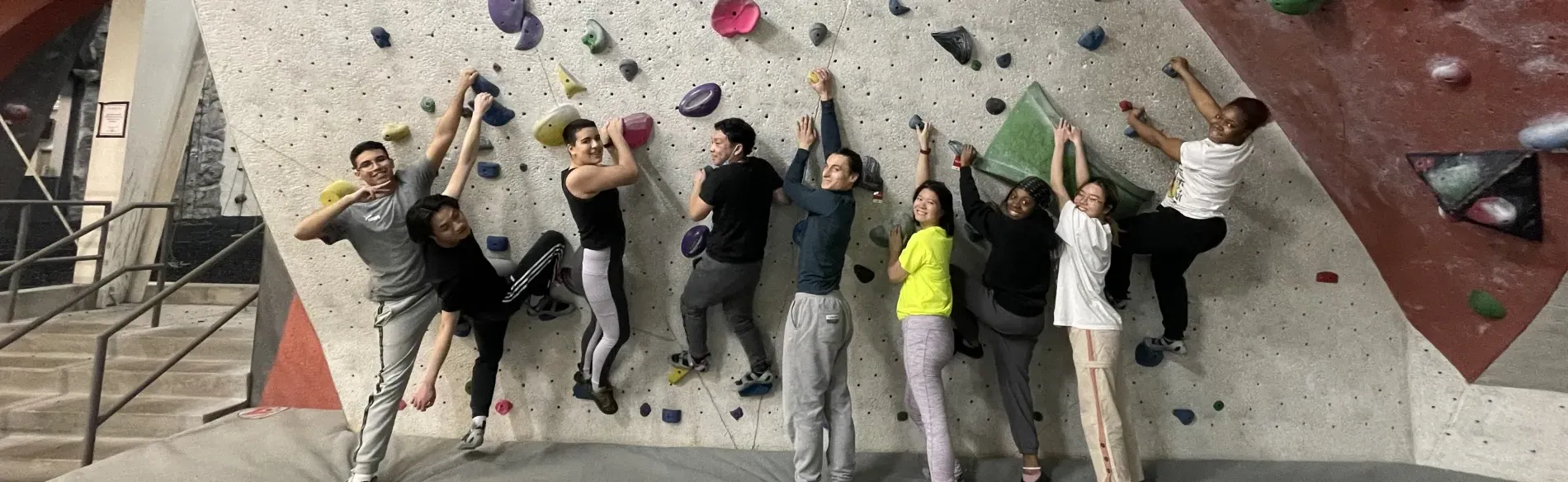 group photo in front of rock climbing wall