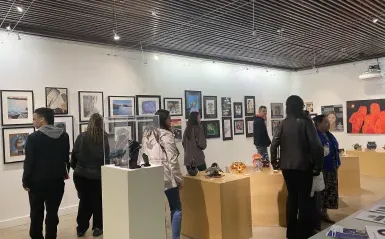 people gather in the gallery to view art 